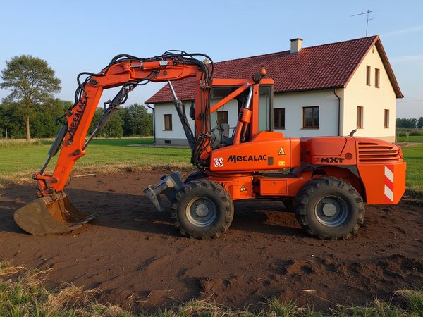 Koparka rozplantowuje ziemię na działce przed domem